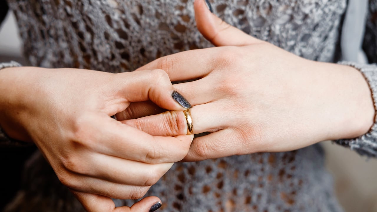 Una mujer se quita un anillo de compromiso, conflicto familiar, primer plano
