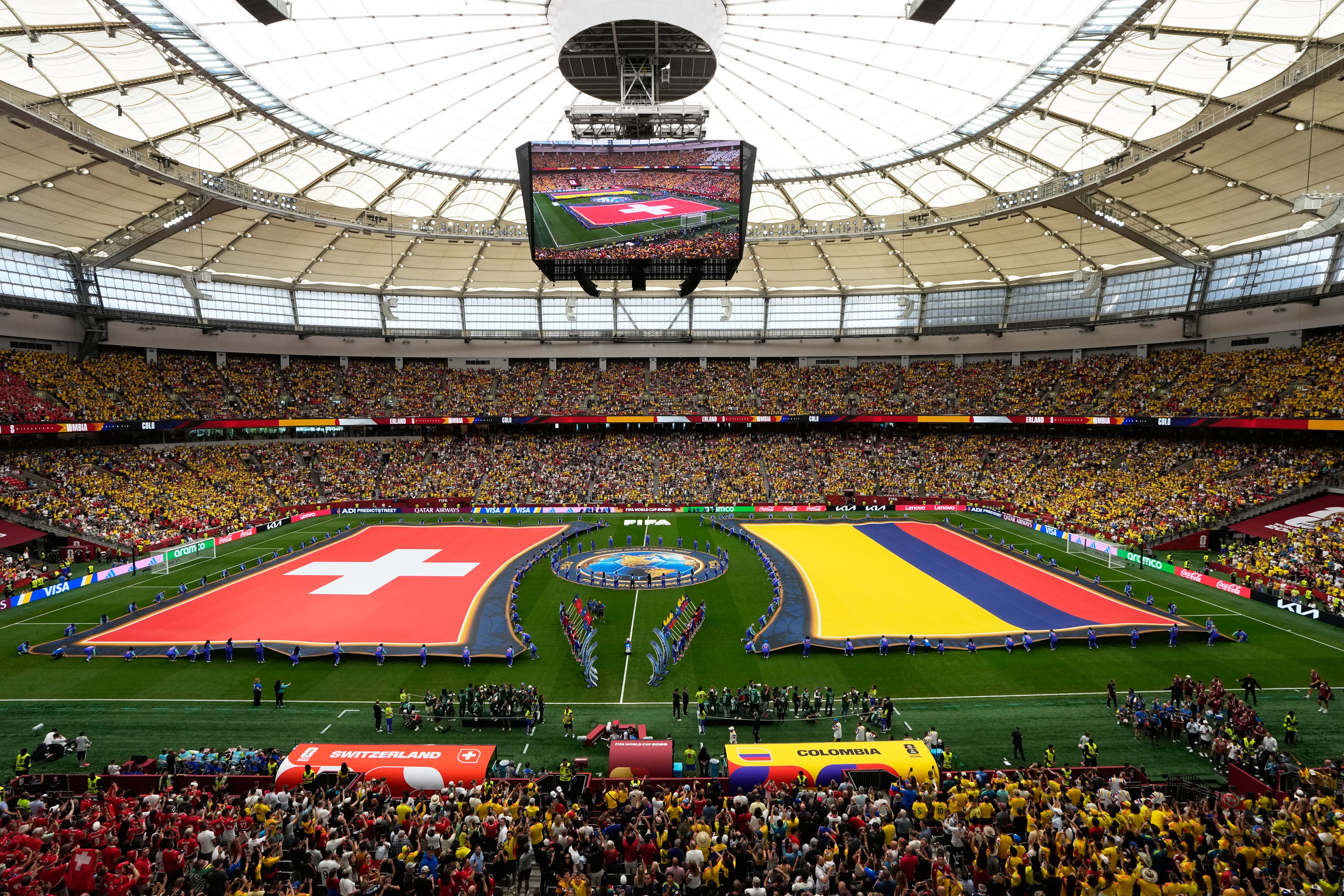 The flags of Switzerland, left, and Colombia, are displayed before their the World Cup round of 16 soccer match in Vancouver, British Columbia, Tuesday, July 7, 2026. (AP Photo/Gregory Bull)