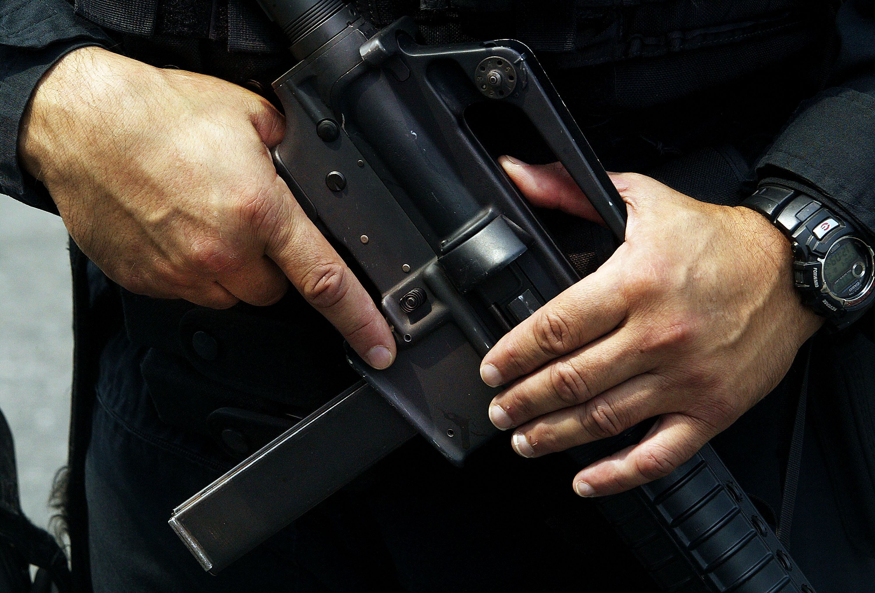 Un oficial de policía de Newark fuertemente armado sostiene su arma mientras hace guardia afuera del edificio de Prudential Insurance Company el 10 de agosto de 2004 en Newark, Nueva Jersey.