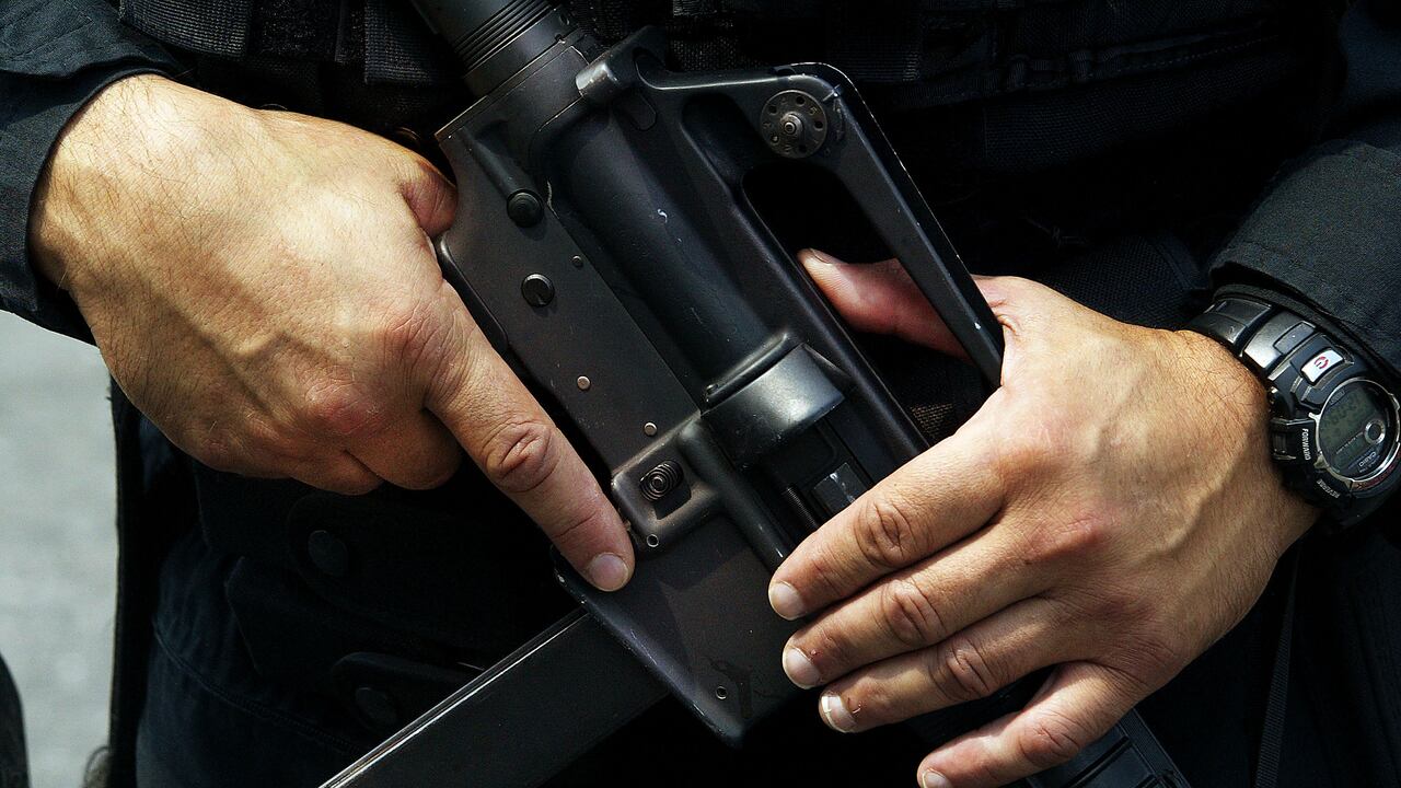 Un oficial de Policía de Newark fuertemente armado sostiene su arma mientras hace guardia afuera del edificio de Prudential Insurance Company el 10 de agosto de 2004 en Newark, Nueva Jersey.