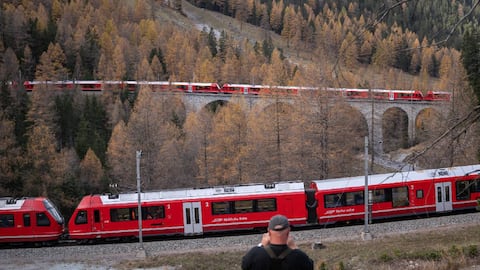 Un miembro del público captura imágenes cuando un tren con 100 vagones pasa cerca de Bergun, el 29 de octubre de 2022, durante un intento de récord del Rhaetian Railway (RhB).