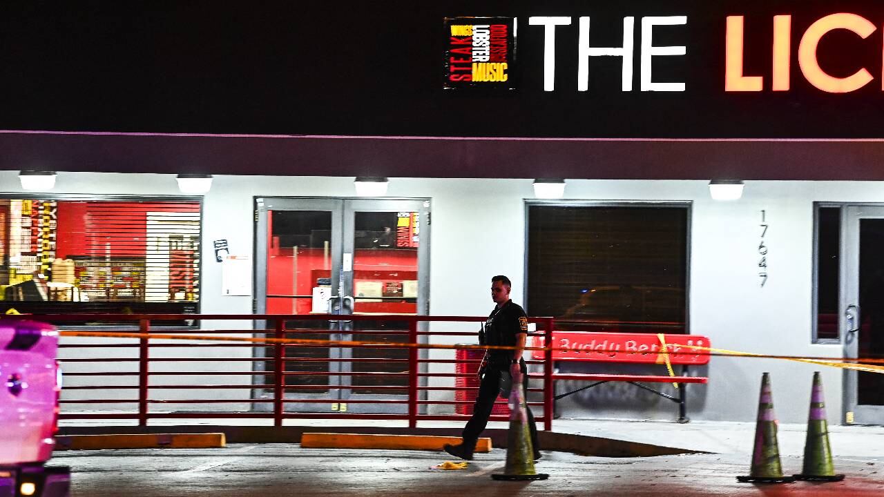 Un oficial de policía de Miami Gardens sale del restaurante "The Licking" donde se lleva a cabo una investigación de tiroteo.
