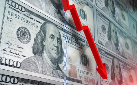 Loss in American dollar. Red arrow graph is showing a drastic fall over American dollar background. Selective focus. Horizontal composition with copy space.