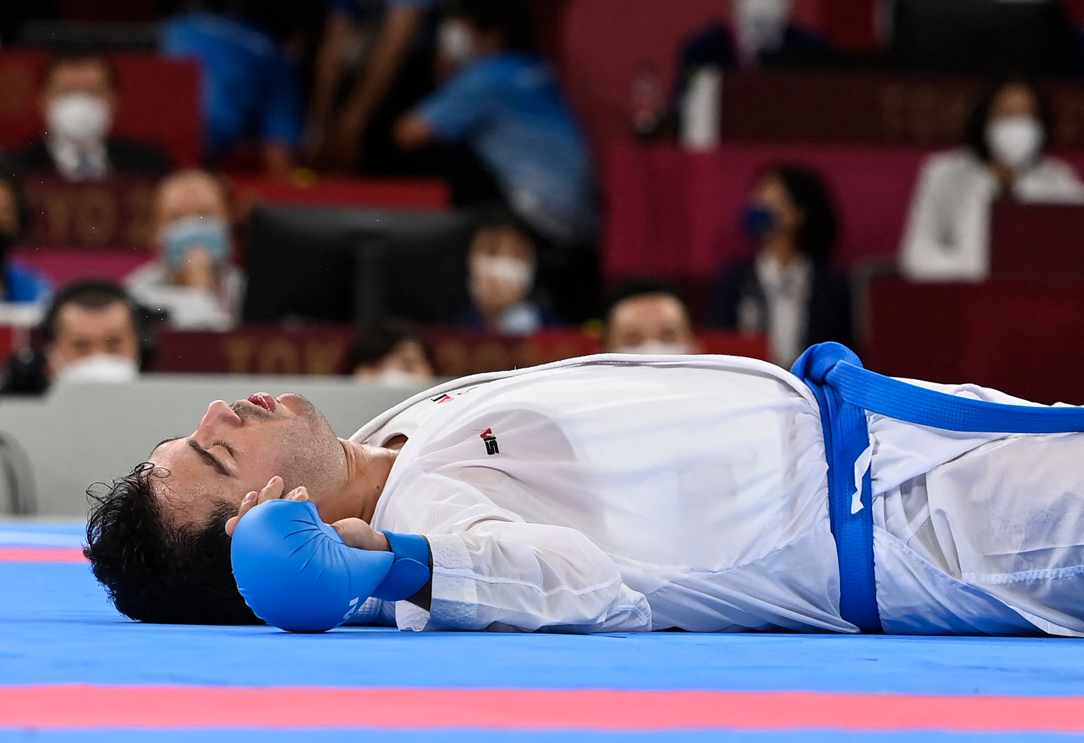 Sajad Ganjzadeh de Irán yace inmóvil después de una lesión en la final de kumite + 75 kg masculino contra Tareg Hamedi de Arabia Saudita en la competencia de karate durante los Juegos Olímpicos de Tokio 2020 en el Nippon Budokan en Tokio el 7 de agosto de 2021 (Foto de Alexander NEMENOV / AFP).