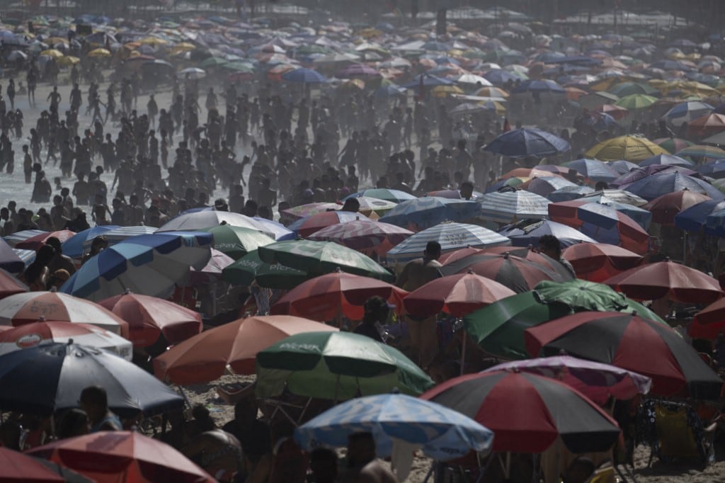 La gente disfruta del día en la playa de Copacabana en Río de Janeiro, Brasil, el 16 de febrero de 2025. (Foto de Pablo PORCIUNCULA / AFP)