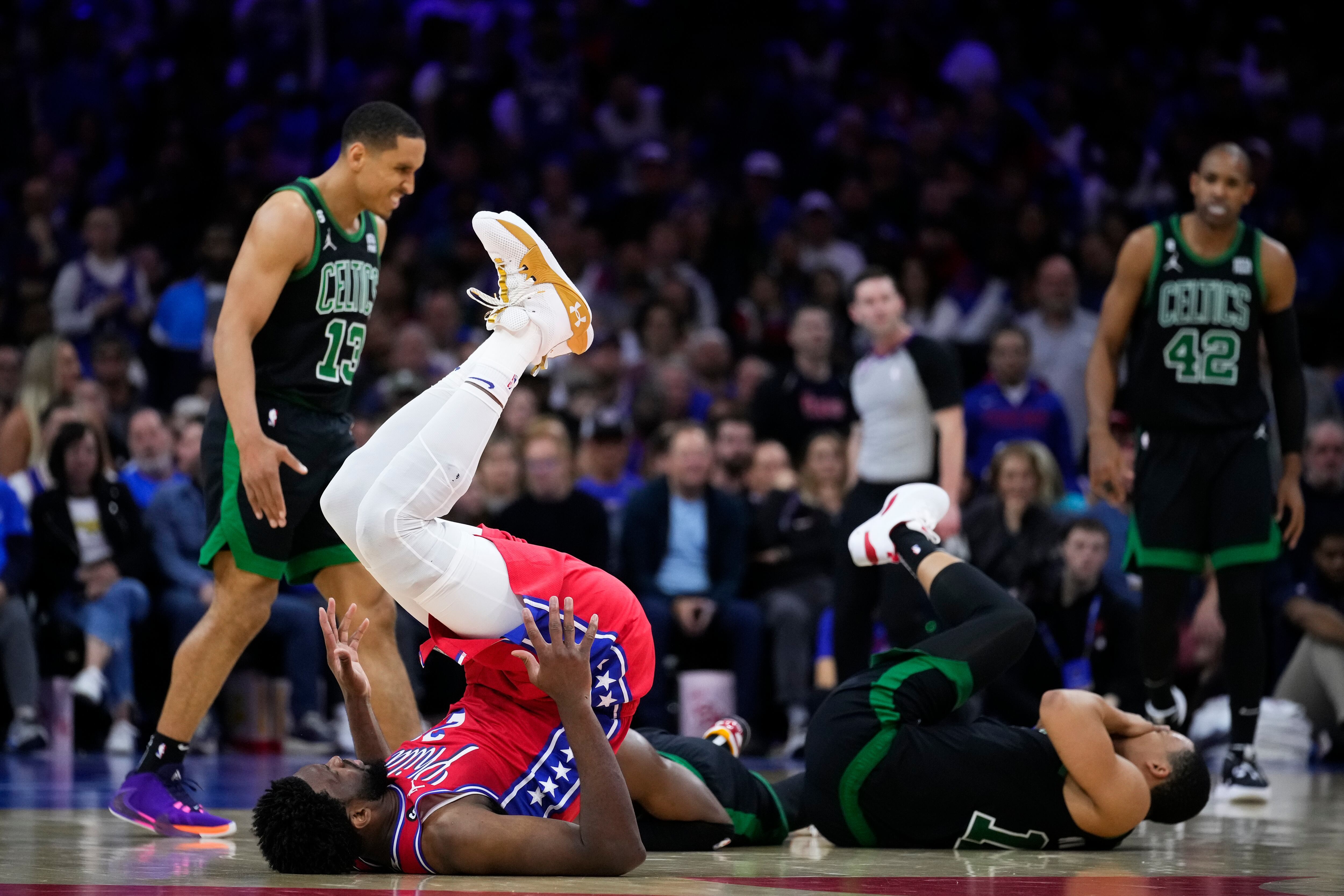 Joel Embiid, de los 76ers de Filadelfia y Grant Williams, de los Celtics de Boston, caen tras una colisión en la semifinal de la Conferencia ESte, el viernes 5 de mayo de 2023 (AP Foto/Matt Slocum)