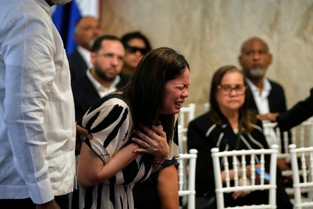Zulinka, centro, hija del cantante dominicano Rubby Perez , que falleció al derrumbarse el techo del centro nocturno Jet Set mientras daba un recital de merengue, llora en el velorio del artista, en el Teatro Nacional Eduardo Brito en Santo Domingo, República Dominicana, el jueves 10 de abril de 2025. (AP Foto/Matias Delacroix)