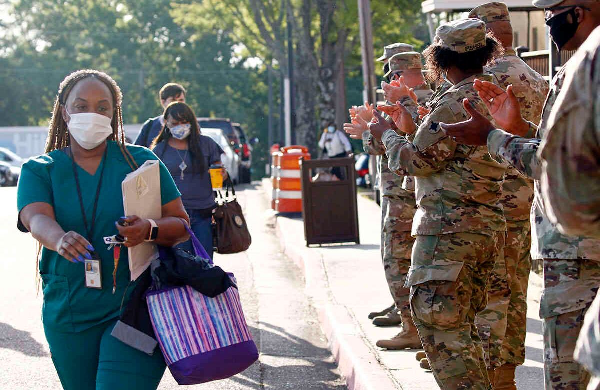 Los miembros de la Guardia Nacional del Aire y el Ejército de Mississippi, aplauden los médicos entrantes y salientes en el Montgomery VA Medical Center en Jackson, Mississippi. El gesto buscaba honrar al personal médico por sus esfuerzos al trabajar para combatir el coronavirus en el último día de la Semana Nacional de Enfermeras. Foto: Rogelio V. Solís / AP.