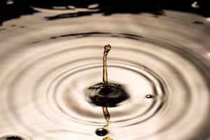 a drop of coca cola or pepsi with circular waves around