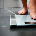 Pies descalzos femeninos con báscula en el baño. peso obesidad