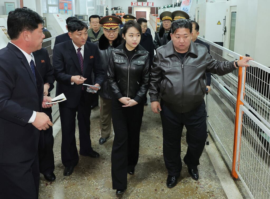 En esta fotografía, facilitada por el gobierno norcoreano, su líder, Kim Jong Un (a la derecha), y su hija visitan una fábrica de pistolas y otras armas ligeras en un lugar no revelado de Corea del Norte, el miércoles 11 de marzo de 2026.