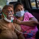 Una paciente de covid espera dentro de un carro mientras recibe oxígeno proporcionado por una casa de culto sij en New Delhi, India