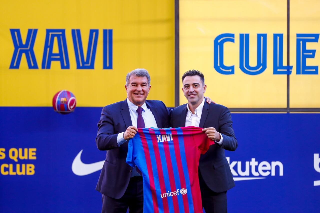 FC Barcelona's new signing coach Xavi Hernandez, right, poses next to FC Barcelona president Joan Laporta during his official presentation at the Camp Nou stadium in Barcelona, Spain, Monday, Nov. 8, 2021. Xavi, who thrived in Barcelona's midfield alongside Messi and Andres Iniesta, was officially introduced as coach on the field of the Camp Nou with a reception usually only offered to top players. (AP Photo/Joan Monfort)