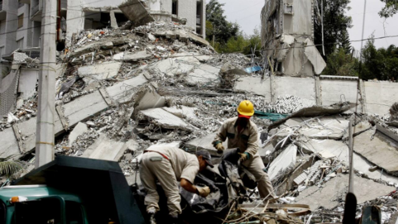Integrantes de equipos de rescate remueven escombros en el edificio Space.