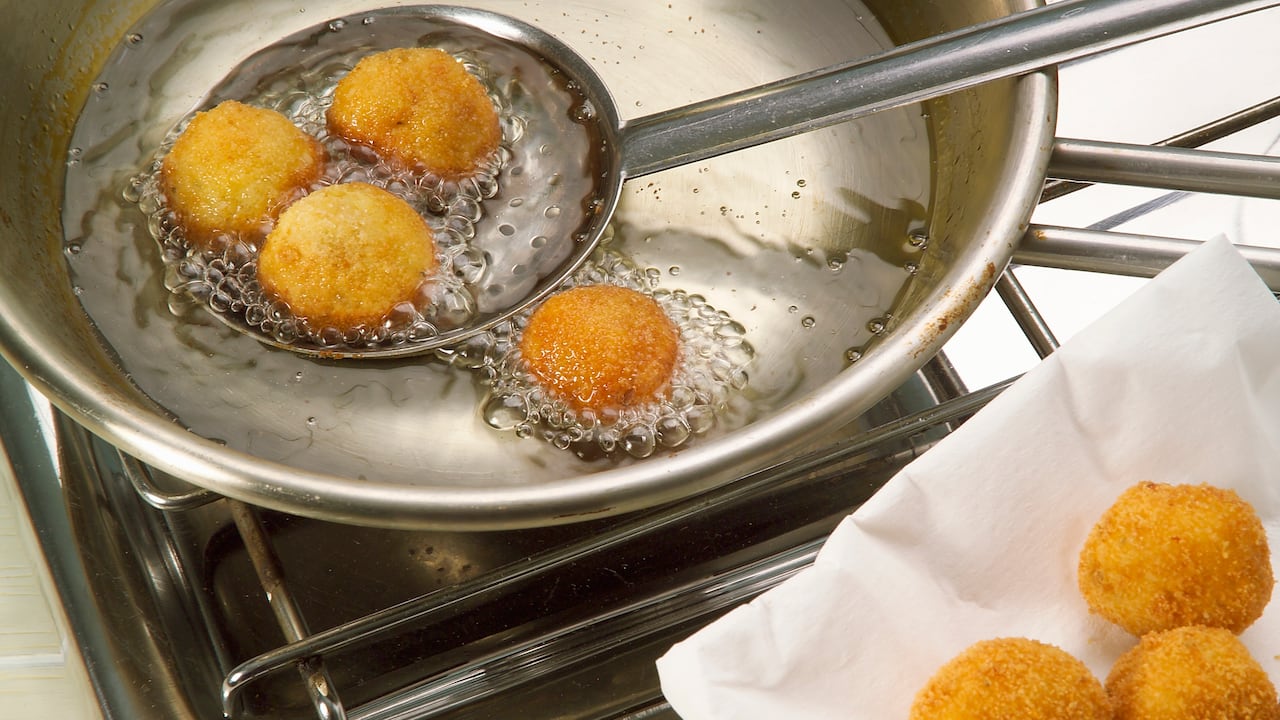 UNSPECIFIED - JANUARY 27: Rolled balls of mashed potatoes, marjoram, pine nuts, parmesan and egg yolk, fried in hot oil. Ligurian cuculli (fried mashed potato dumplings) step 4. (Photo by DeAgostini/Getty Images)