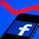 Facebook logo displayed on a phone screen and an illustrative graph displayed on a screen are seen in this illustration photo taken in Krakow, Poland on February 6, 2022. (Photo illustration by Jakub Porzycki/NurPhoto via Getty Images)