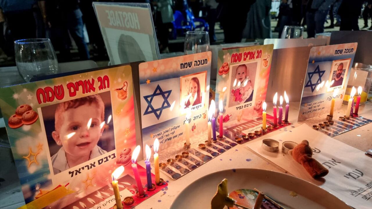 TEL AVIV, ISRAEL - DECEMBER 9: Hanukkah candles are lit at places set at the festival table for the Bibas family, an Israeli family including 11-month-old baby Kfir, his 4-year-old brother Ariel and their parents Shiri and Yarden, who are being held hostage by Hamas in the Gaza Strip, in The Hostages and Missing Square, on December 9, 2023 in Tel Aviv, Israel. Thousands of Israelis called for the immediate release of the remaining 138 Israeli hostages held by Hamas during a rally in the square, which coincided with the third night of the Jewish festival of Hanukkah. (Photo by David Silverman/Getty Images)
