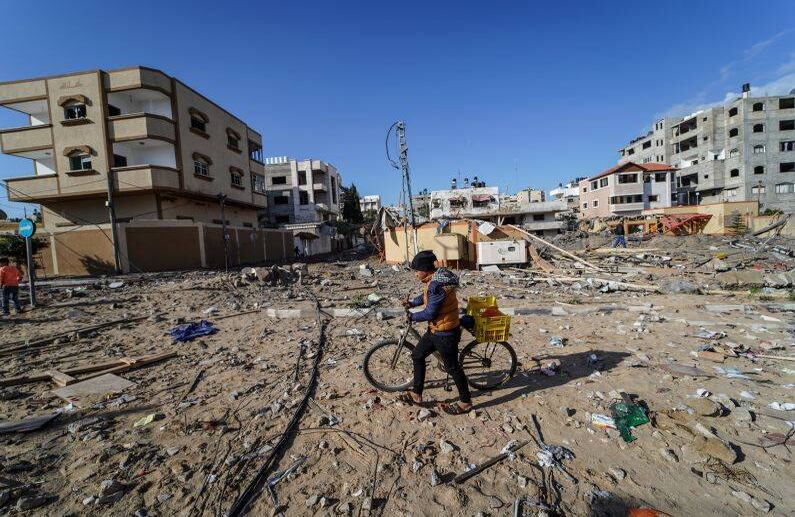 Un niño que empuja su bicicleta entre los escombros después de un ataque aéreo israelí en Gaza. FOTO: Mohamed Zarandah / SOPA Images / LightRocket a través de Getty Images