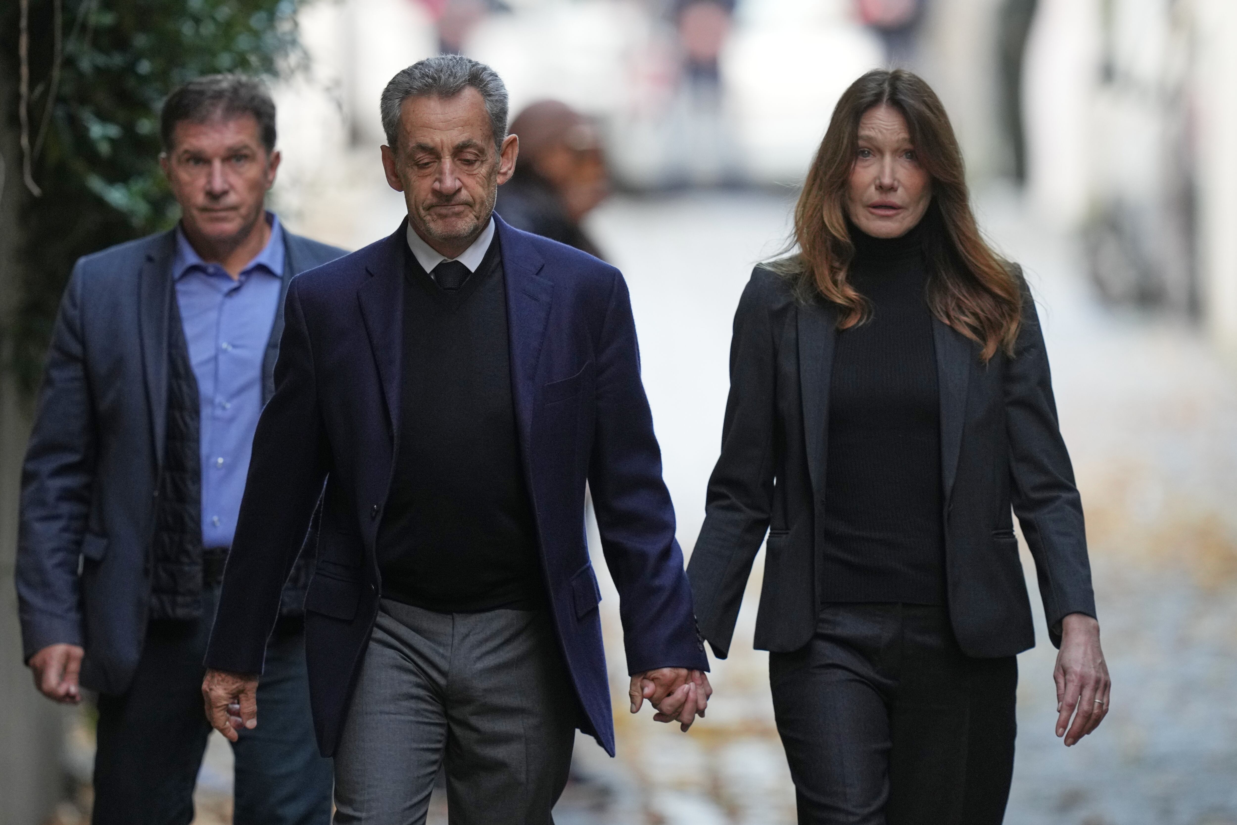 El expresidente francés Nicolas Sarkozy y su esposa Carla Bruni-Sarkozy salen de su casa el martes 21 de octubre de 2025 en París mientras Nicolas Sarkozy se dirige a prisión para cumplir condena por una conspiración criminal para financiar su campaña electoral de 2007 con fondos de Libia. (Foto AP/Thibault Camus)