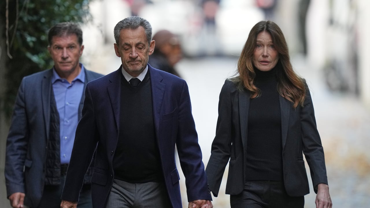 El expresidente francés Nicolas Sarkozy y su esposa Carla Bruni-Sarkozy salen de su casa el martes 21 de octubre de 2025 en París mientras Nicolas Sarkozy se dirige a prisión para cumplir condena por una conspiración criminal para financiar su campaña electoral de 2007 con fondos de Libia. (Foto AP/Thibault Camus)