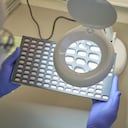 En esta foto proporcionada por Pfizer, un técnico de laboratorio inspecciona visualmente muestras de tabletas de Paxlovid en Freiburg, Alemania, en diciembre de 2021. (Pfizer via AP)