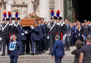 The coffin of media mogul and former Italian Premier Silvio Berlusconi leaves the Milan's Gothic Cathedral at the end his state funeral in northern Italy, Wednesday, June 14, 2023. Berlusconi died at the age of 86 on Monday in a Milan hospital where he was being treated for chronic leukemia. Second from right is Italian Premier Giorgia Meloni. (AP Photo/Luca Bruno)