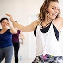Instructor teaching dance to students at fitness club. Group of women dancing in a fitness dance studio.