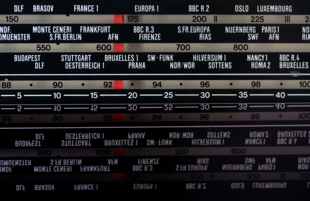 Sobre una mesa hay una antigua radio analógica con varias frecuencias y transmisores. El Día Mundial de la Radio, que se celebra el 13 de febrero, tiene como objetivo llamar la atención sobre la importancia de la radio.