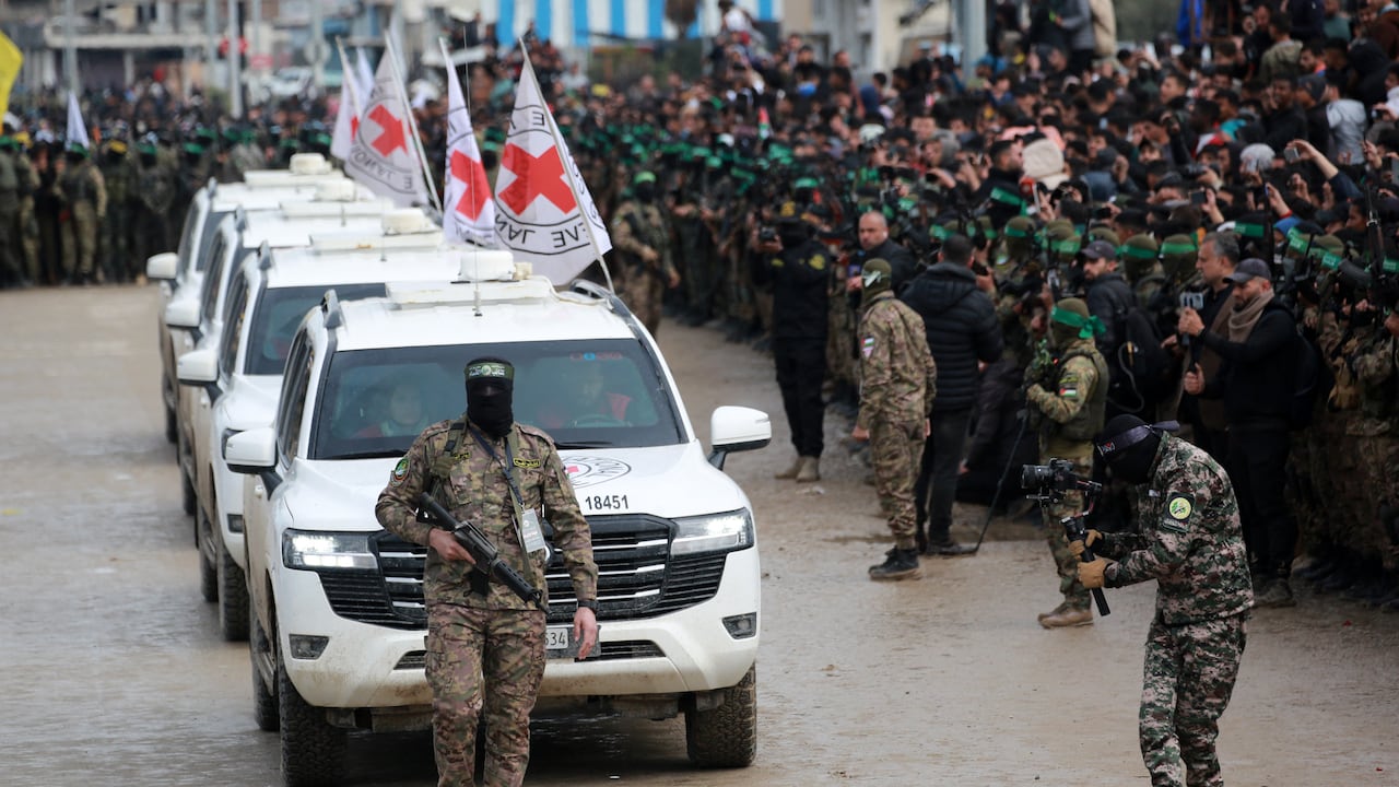 Un combatiente palestino de Hamas precede a los vehículos de la Cruz Roja Internacional (CICR) cuando llegan a Nuseirat, en el centro de la Franja de Gaza, para recibir a tres rehenes israelíes como parte del séptimo intercambio de rehenes-prisioneros el 22 de febrero de 2025. Tres rehenes israelíes más fueron liberados por militantes de Hamas en una ceremonia en el centro de Gaza el 22 de febrero, después de que otros dos fueron liberados en la parte sur del territorio palestino. (Foto de Bashar TALEB / AFP)