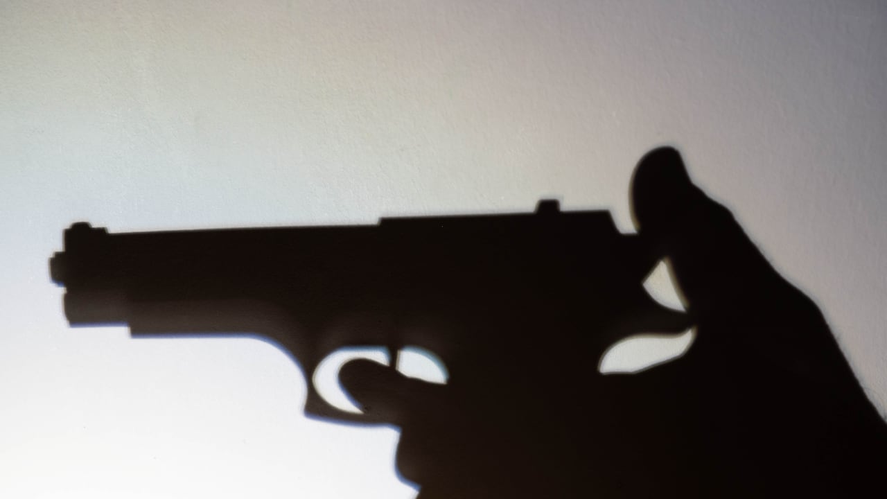 Silueta de una persona que va a disparar con un arma.
