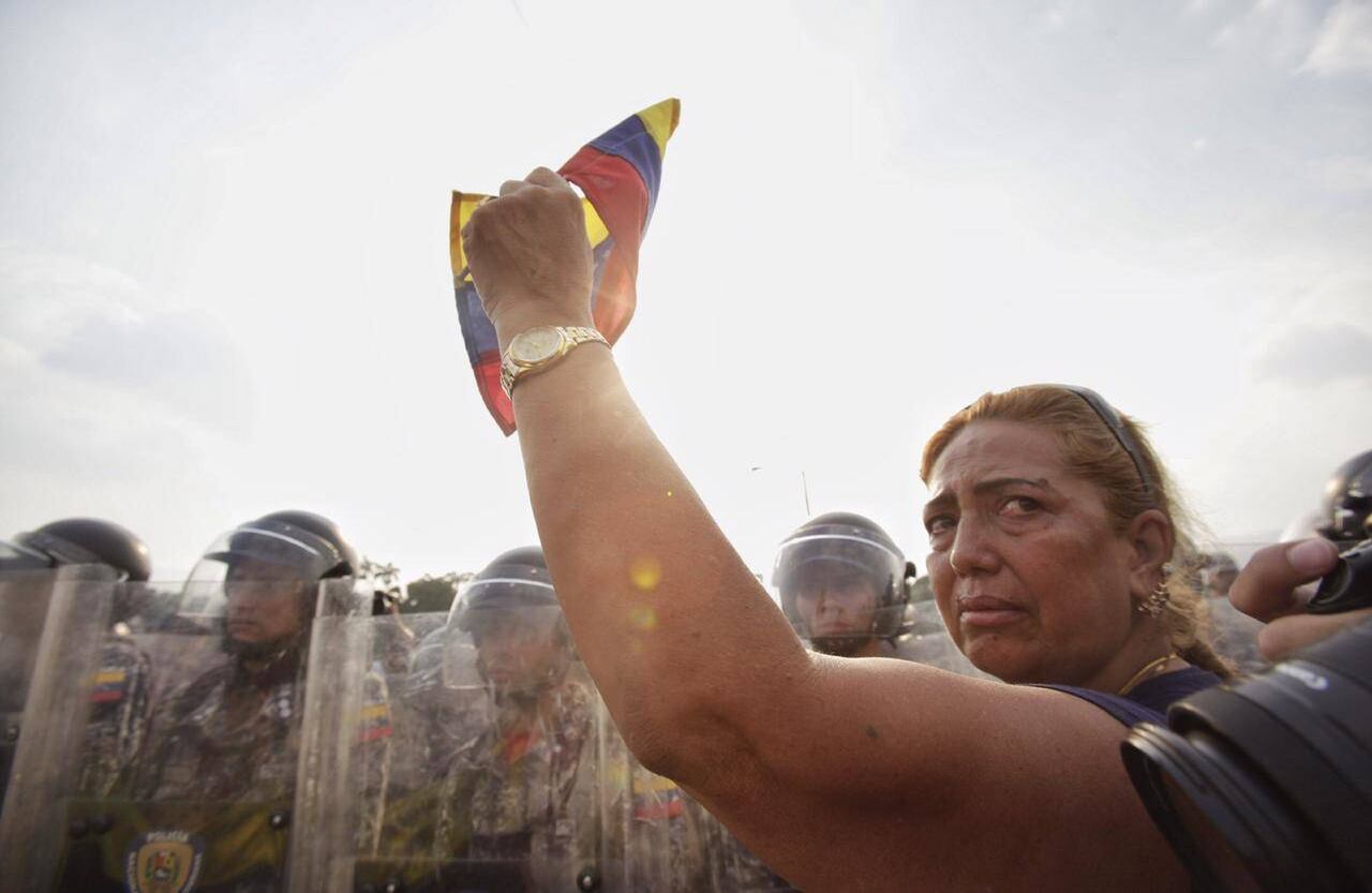 La tristeza consume a esta mujer que implora a los guardias que dejan entrar la ayuda humanitaria. Foto: Diana Rey Melo SEMANA
