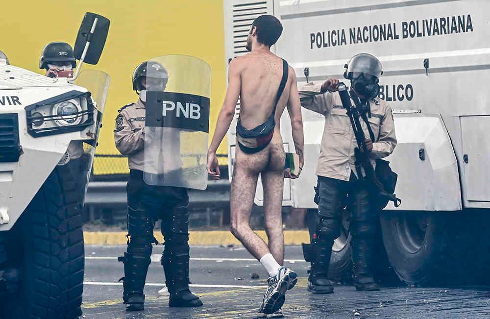 "¡No lancen más bombas, por favor!", suplicó Hans Wuerich, de 27 años, completamente desnudo sobre un blindado, mientras caminaba impávido ante una nube de gases lacrimógenos. Desconcertados, agentes de la Policía Nacional le ordenaron bajarse del vehículo y lo obligaron a retroceder disparándole perdigones, que le dejaron varias marcas en la espalda.