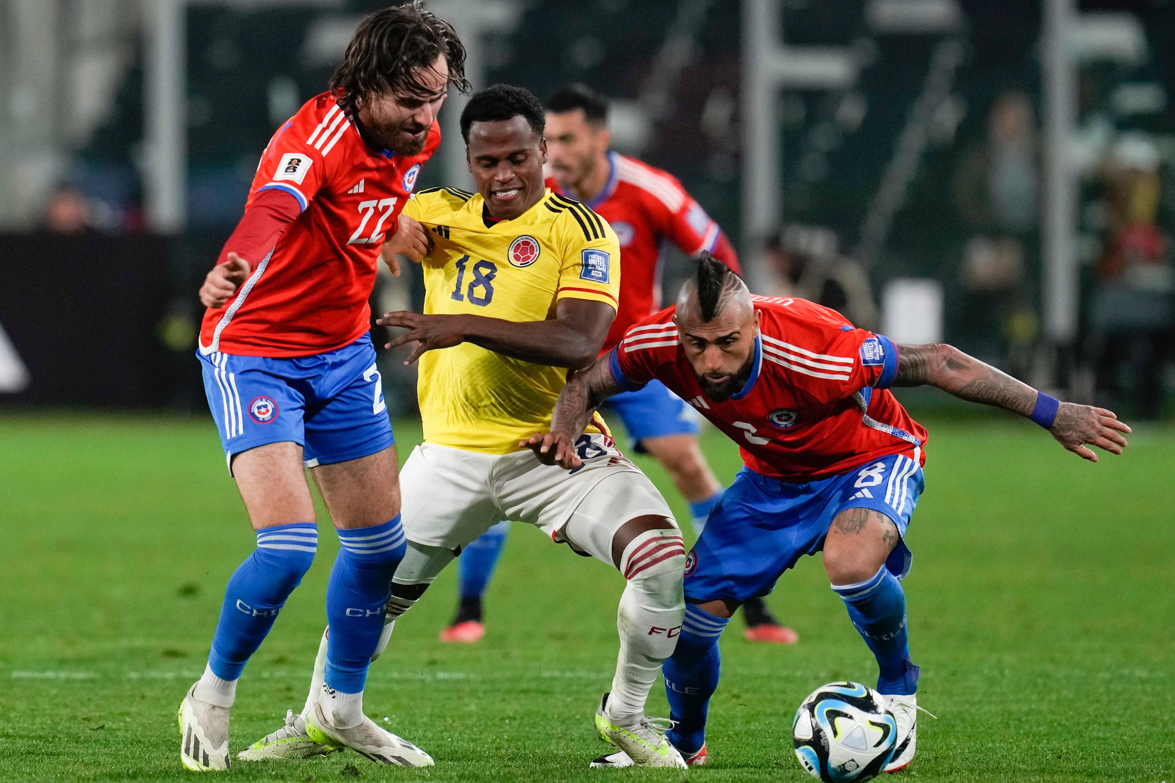 Chile's Ben Brereton, left, and Arturo Vidal, right, fight for the ball with Colombia's Jhon Arias during a qualifying soccer match for the FIFA World Cup 2026 at Monumental stadium in Santiago, Chile, Tuesday, Sept. 12, 2023. (AP Photo/Esteban Felix)