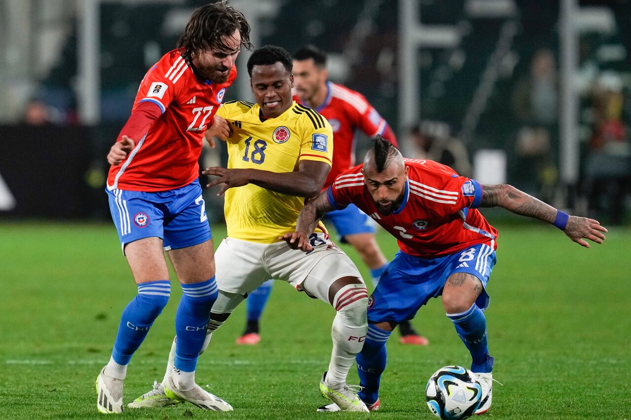 Chile's Ben Brereton, left, and Arturo Vidal, right, fight for the ball with Colombia's Jhon Arias during a qualifying soccer match for the FIFA World Cup 2026 at Monumental stadium in Santiago, Chile, Tuesday, Sept. 12, 2023. (AP Photo/Esteban Felix)