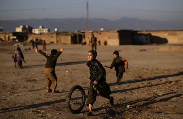 Niños afganos juegan con neumáticos durante su refugio en las afueras de Islamabad, Pakistán. (AP)