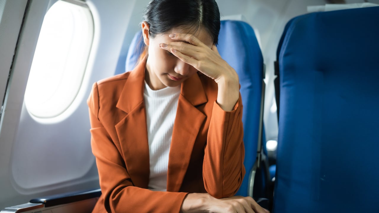 Pasajera de avión sufriendo náuseas y mareos durante el vuelo.