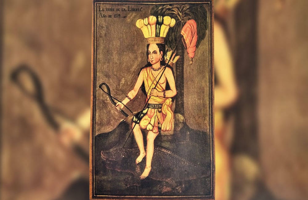 La india de la libertad: Después del grito de la independencia se hizo común celebrarlo sembrando un árbol. La ceremonia iba antecedida por la presencia de una indígena. Esta práctica seguramente fue la inspiración de la pintura La india de la libertad. Los patriotas también tuvieron la osadía de escoger una mujer indígena como símbolo del triunfo obtenido en la batalla de Boyacá. Ella está recostada sobre el tronco de una palmera y sostiene en una mano la lanza con el gorro frigio, símbolo de los revolucionarios franceses. Sus pies, como en la iconografía clásica de América, están apoyados sobre un cocodrilo. Anónimo, 1819, óleo sobre tela, Museo del 20 de Julio.