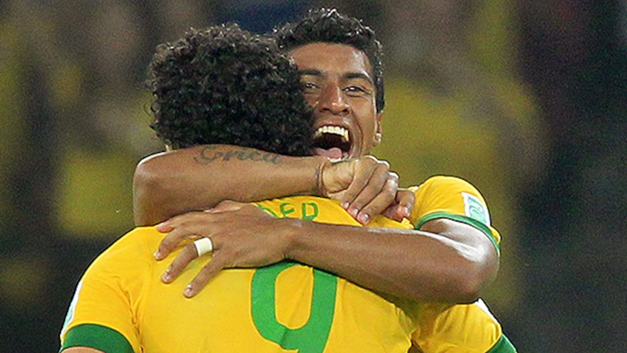 Los jugadores de la selección de fútbol de Brasil Paulinho y Fred celebran la clasificación de su equipo.