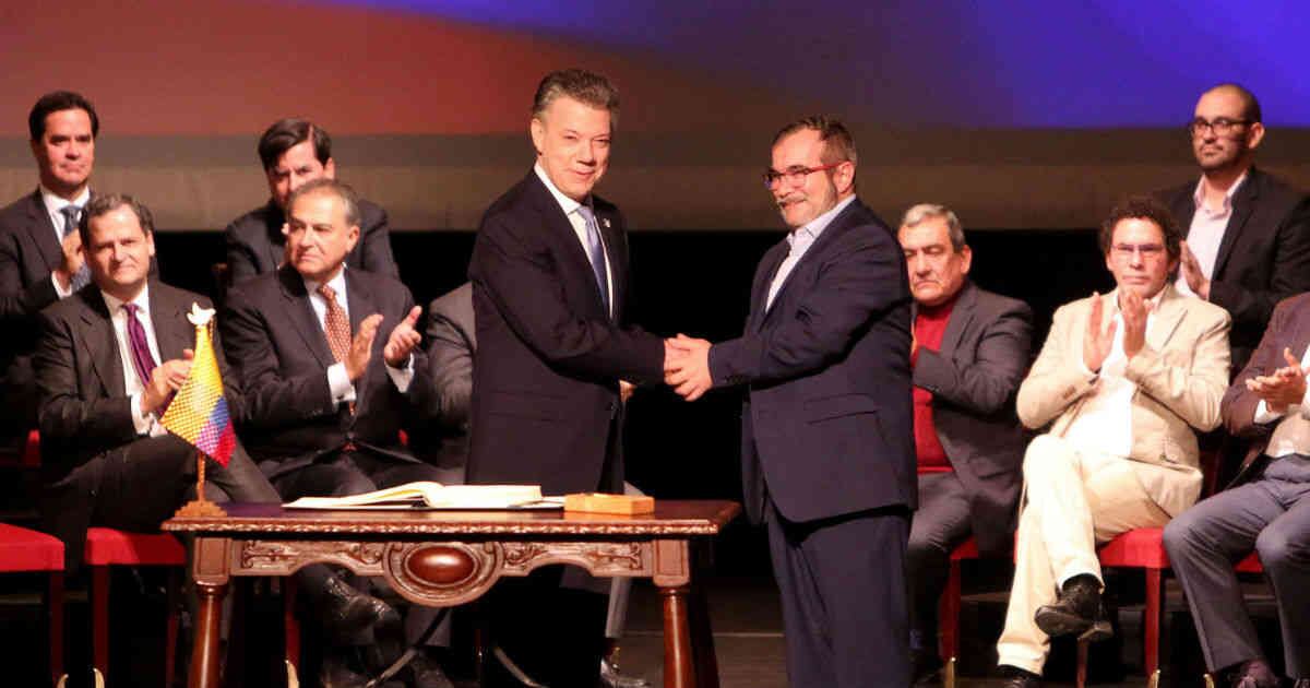 El entonces presidente Juan Manuel Santos y Rodrigo Londoño, alias Timochenko, en la firma del acuerdo de paz, en el teatro Colón, de Bogotá, en 2016. 