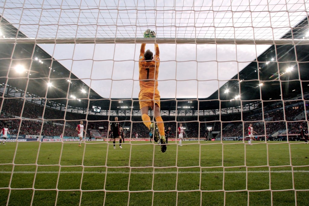 El portero de Augsburgo, Alexander Manninger, protege el balón durante el partido de la Bundesliga entre el FC Augsburg y el FC Bayern München en el SGL Arena el 13 de diciembre de 2014 en Augsburgo, Alemania