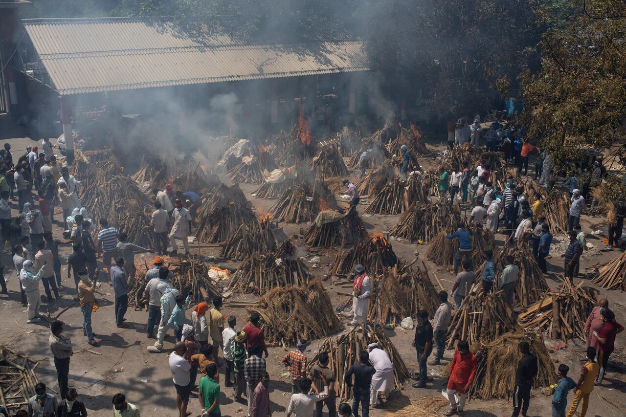 Múltiples piras fúnebres de aquellos que han muerto de covid-19 en un crematorio masivo en New Delhi, India, sábado 24 de abril