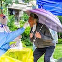 Un trabajador de la salud toma una muestra de un hisopo de un residente para hacerle la prueba del coronavirus Covid-19 (Foto de LIU JIN / AFP) / China OUT