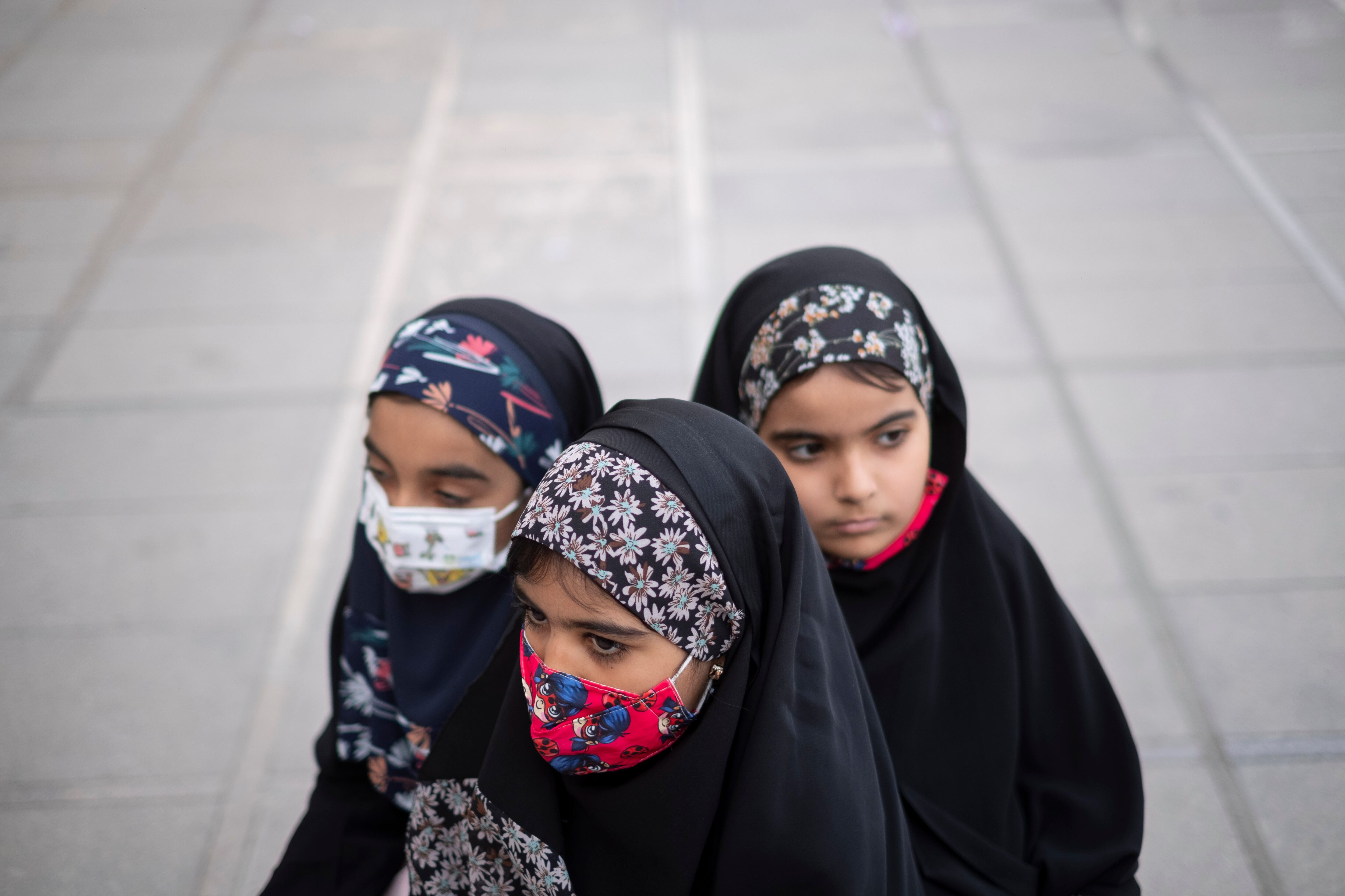 Jóvenes iraníes con velo se sientan en la gran mezquita Imam Khomeini en el centro de Teherán, durante una ceremonia que marca el Día Nacional de las Hijas, el 19 de mayo de 2023.