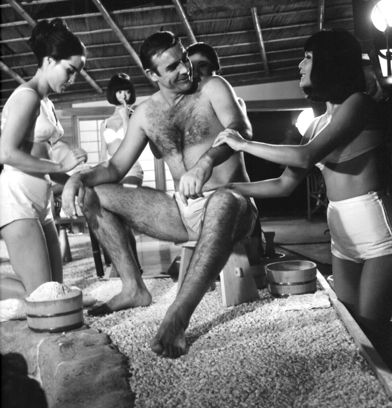 En esta foto de archivo del 26 de septiembre de 1966, el actor británico Sean Connery recibe un baño japonés durante el rodaje de una escena de la película de James Bond en Pinewood Studios cerca de Londres. Las actrices son Yasuko Nagazuni, a la izquierda y Yee Wah Yang a la derecha.