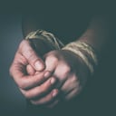 Hombre con las manos atadas en clave baja