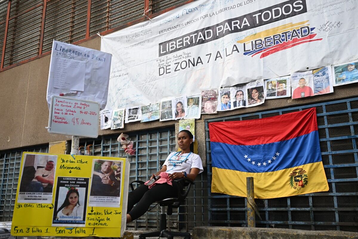 Un familiar de un preso político se sienta en una silla durante una huelga de hambre frente a la cárcel de la Zona 7 de la Policía Nacional Bolivariana (PNB) en Caracas, el 16 de febrero de 2026.