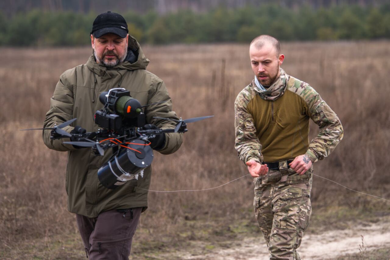 KYIV OBLAST, UKRAINE - JANUARY 29: Ukrainian servicemen carry an FPV drone controlled via a fiber-optic cable in a field during Ukrainian military training on January 29, 2025 in Kyiv Oblast, Ukraine. Using FPV drones controlled via a fiber-optic cable makes it possible to ignore the operation of electronic warfare, because a pilot has a direct connection with a drone through a fiber-optic cable. (Photo by Dan Bashakov/Global Images Ukraine via Getty Images)