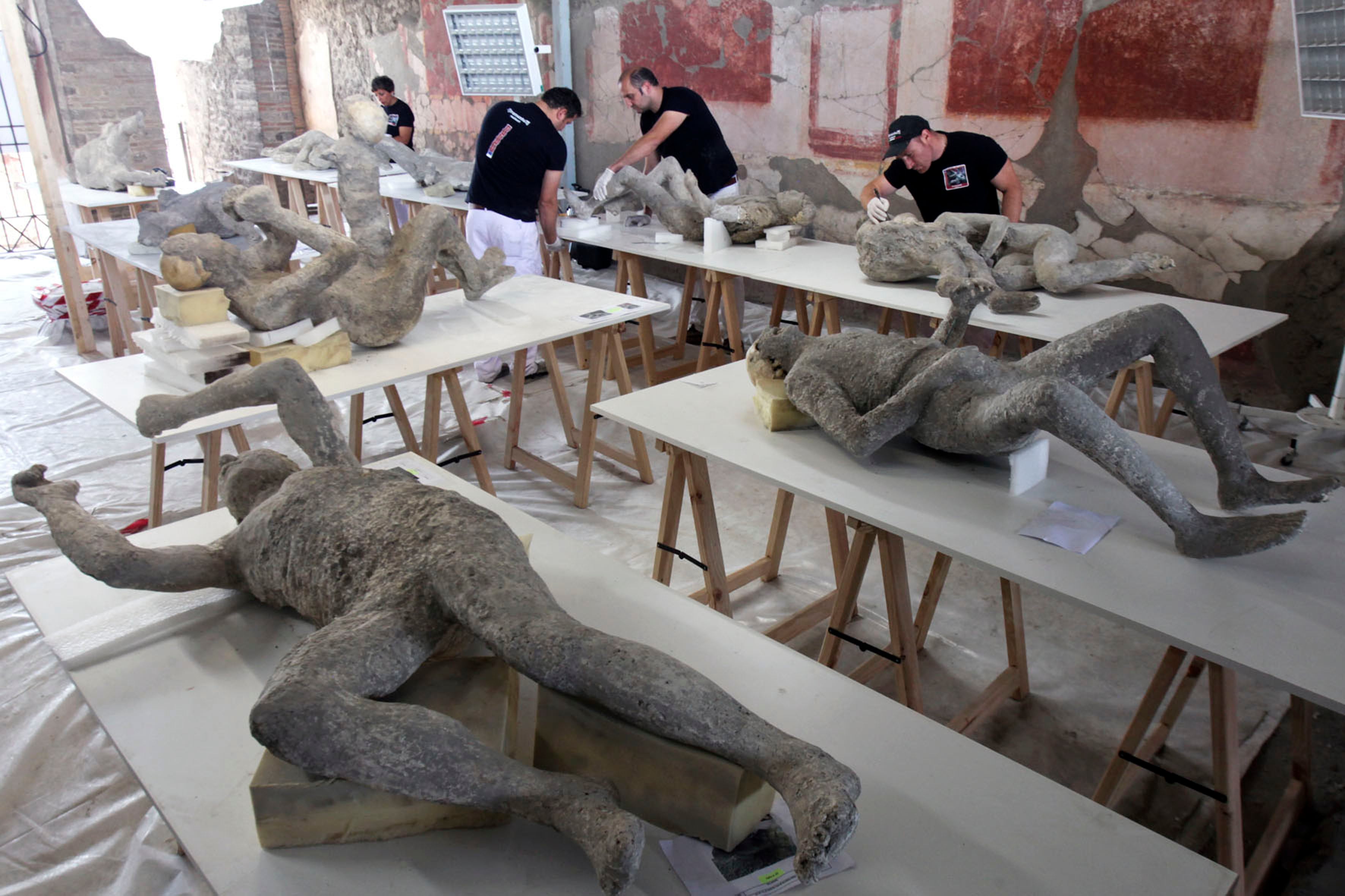 Restauradores y técnicos analizan a las víctimas petrificadas de la erupción del volcán Vesubio del 79 d.C. Dentro de un laboratorio en el sitio arqueológico de Pompeya. Todas las víctimas petrificadas fueron escaneadas con TAC. (Foto de Roberta Basile/KONTROLAB/LightRocket vía Getty Images)