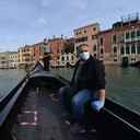 Un gondolero transporta a su primer cliente luego de la reactivación del servicio en los canales de Venecia.