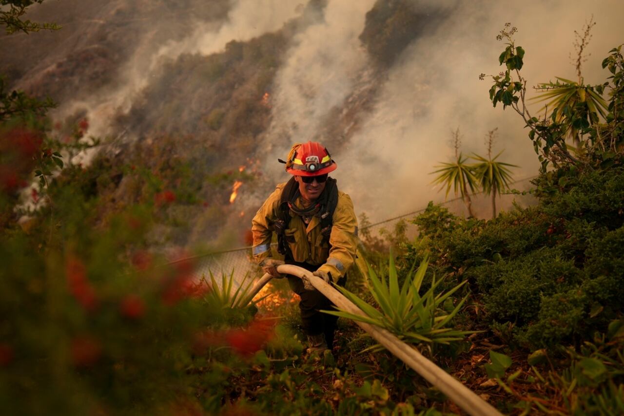 Un bombero prepara una manguera para combatir el incendio Palisades en Mandeville Canyon, el sábado 11 de enero de 2025, en Los Ángeles. (AP Foto/Eric Thayer)